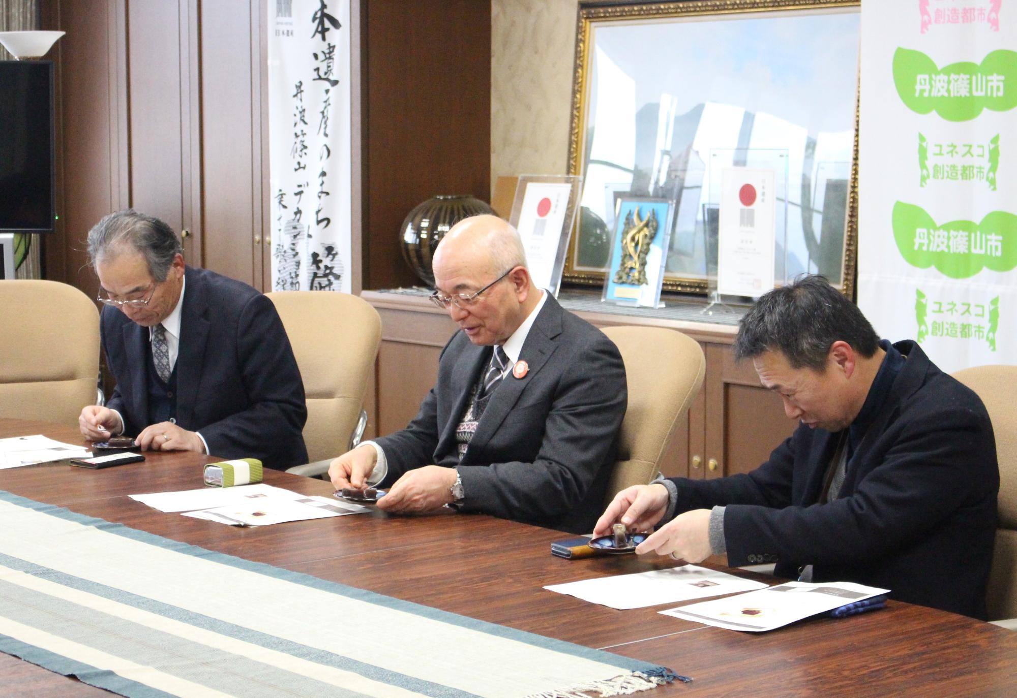 黒枝豆ようかんを試食をする市長と副市長と職員
