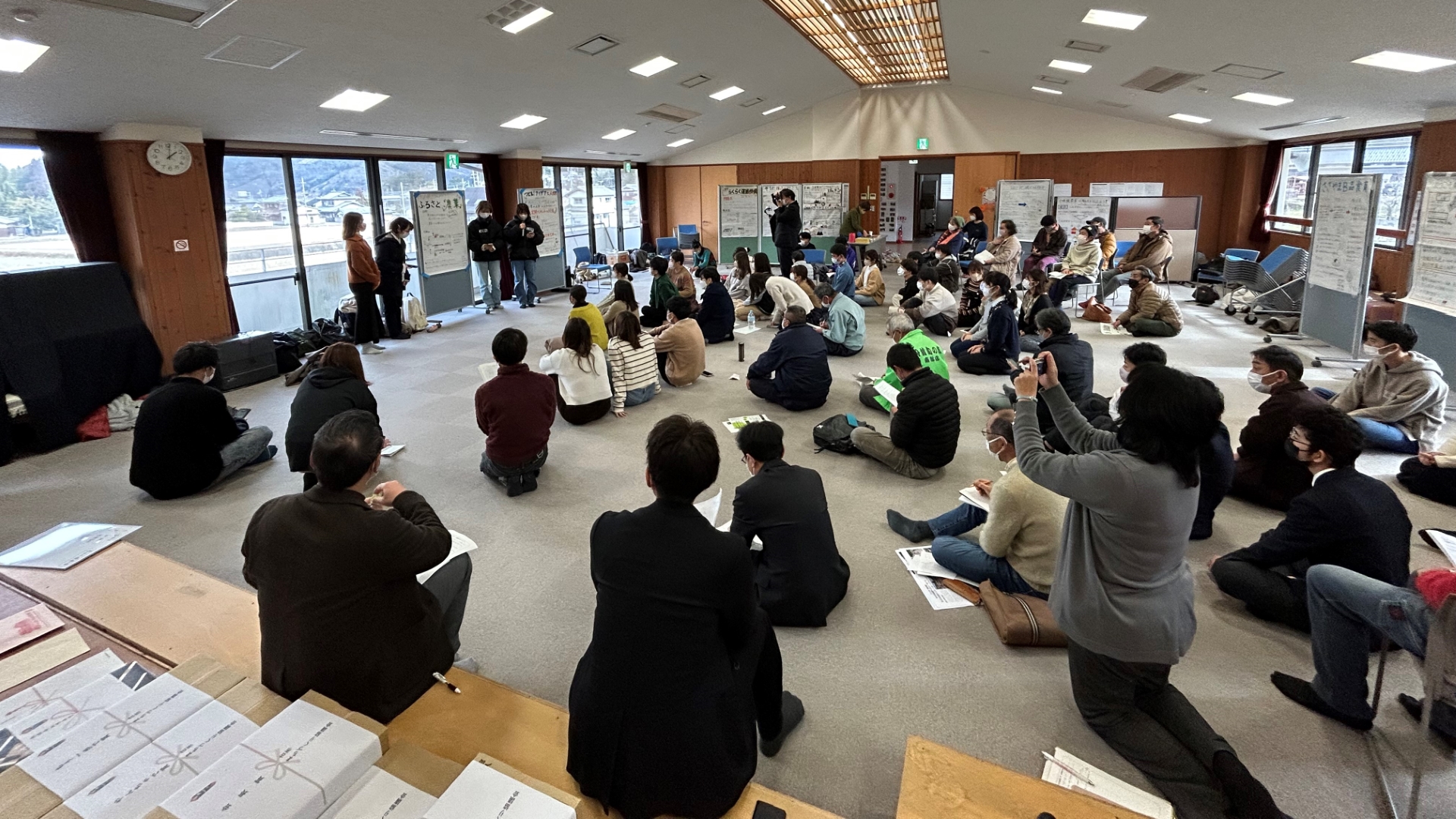 地元の関係者の前で、学生たちが発表している