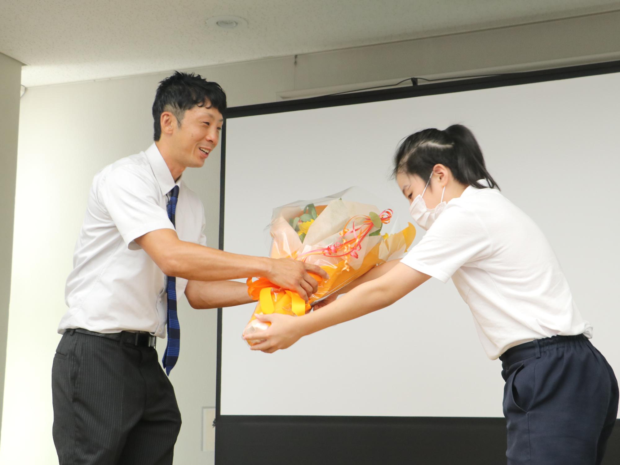 津村さんが角谷選手に花束を贈呈