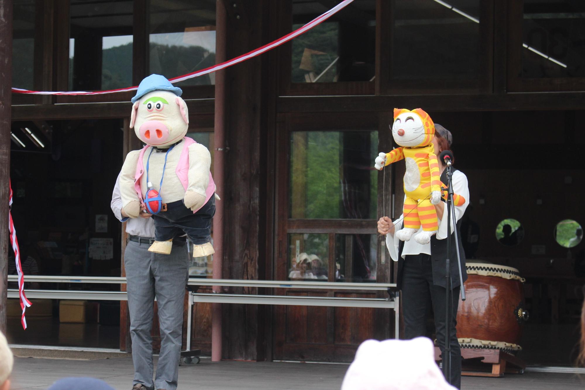 ブタとネコの人形を持っている