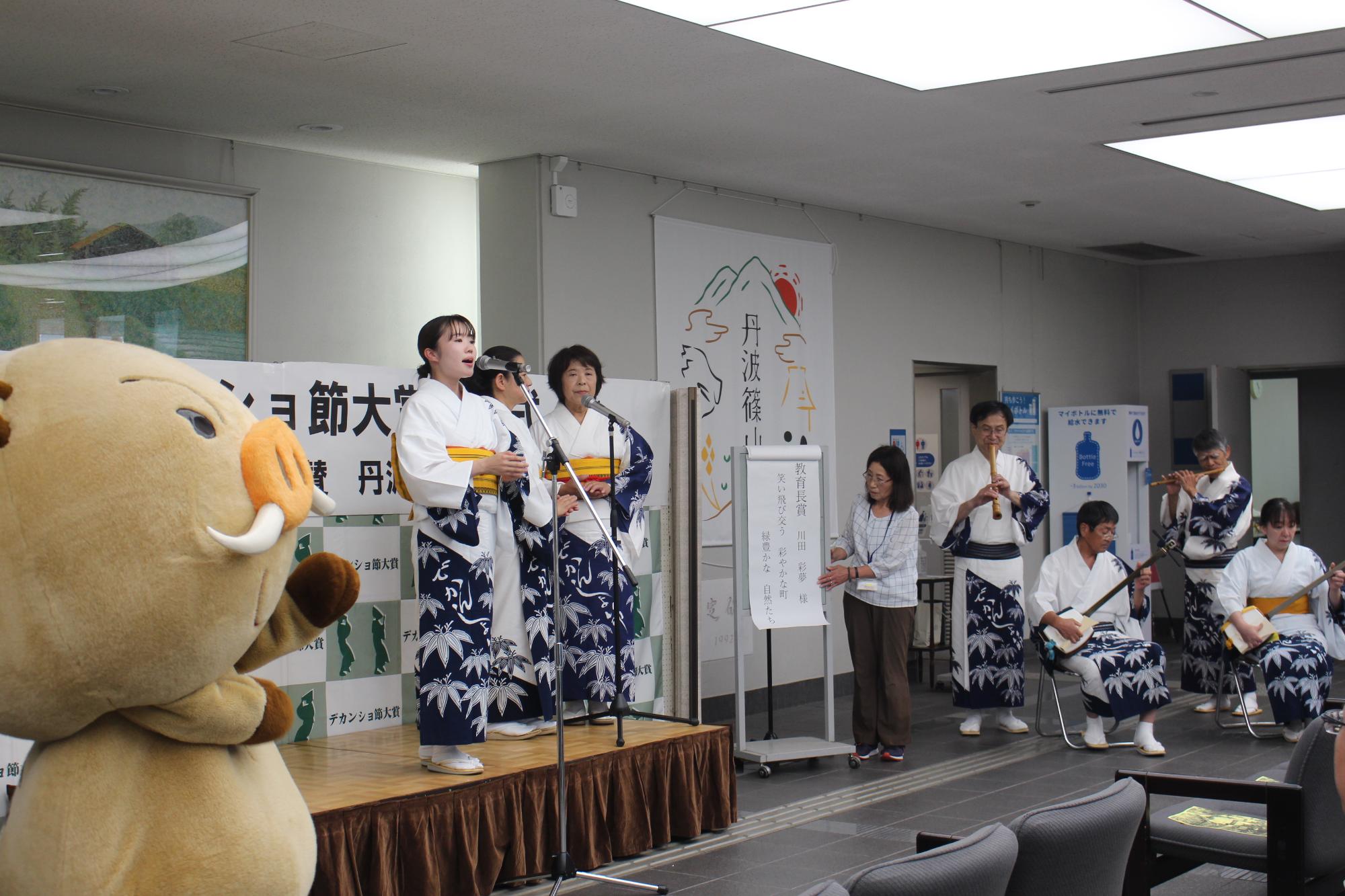 デカンショ節保存会の皆さんが歌唱・演奏し、まるいのが踊っている