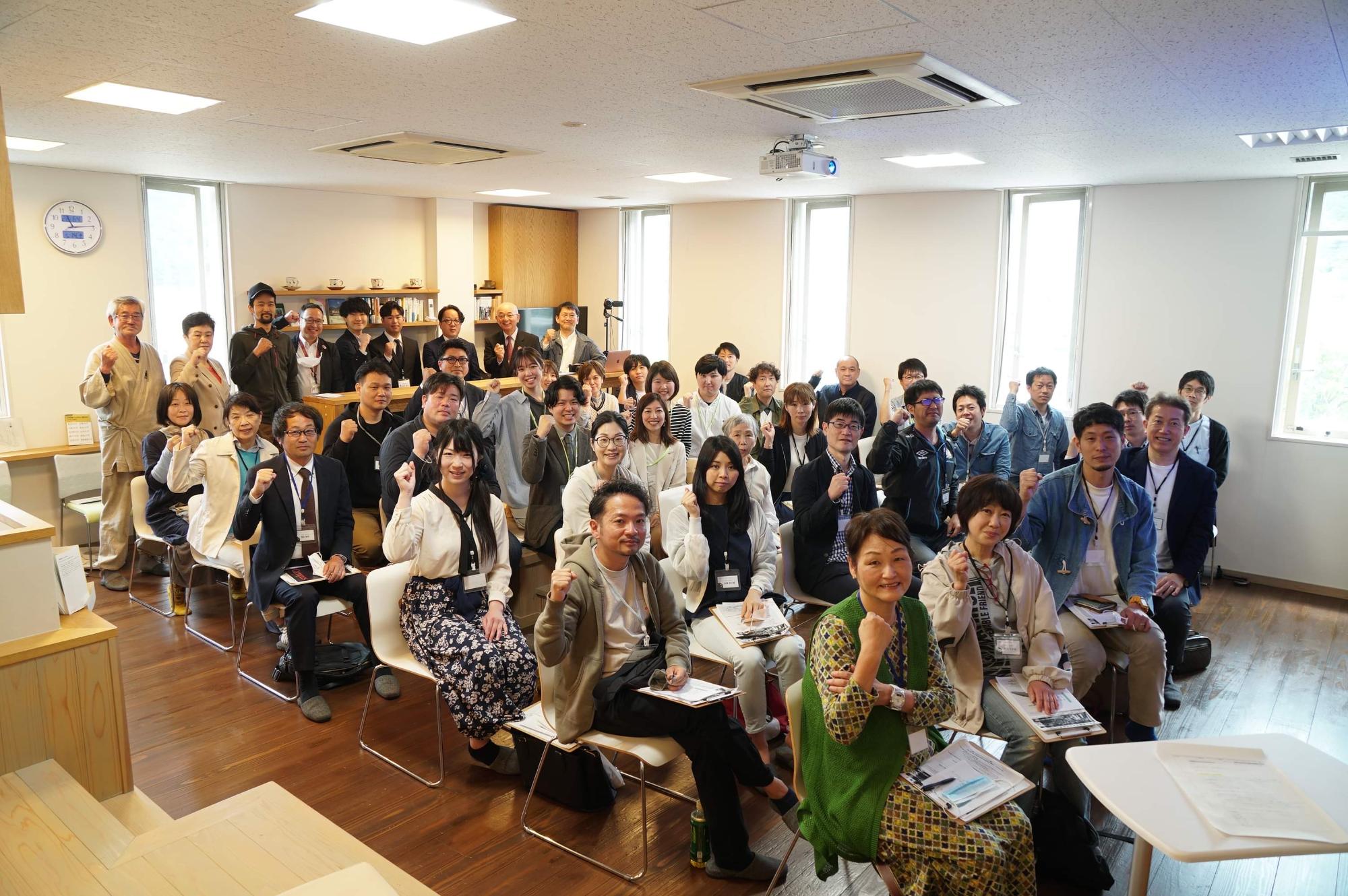 受講生が椅子に座ったたままカメラの方を向いて記念撮影している