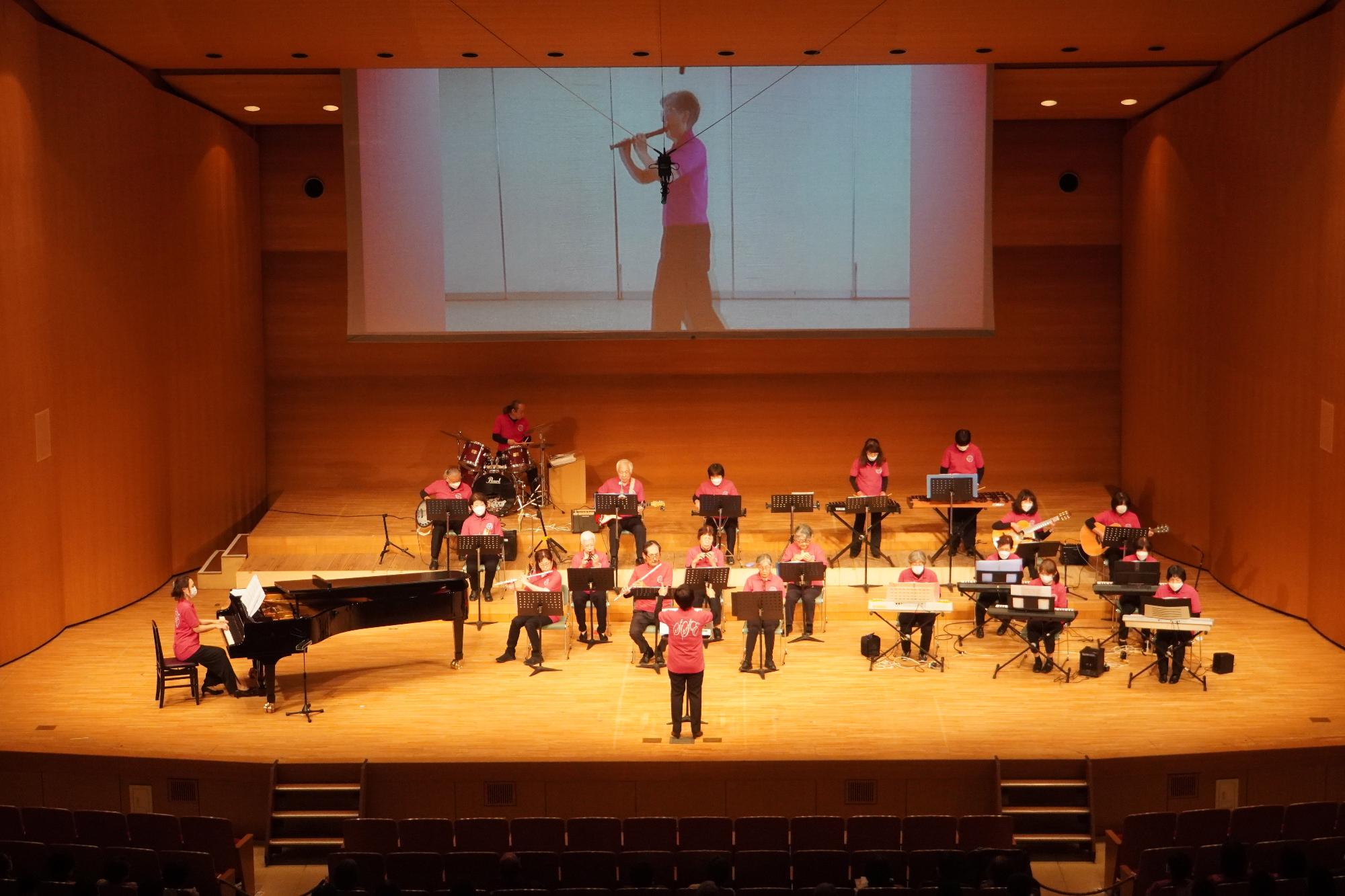 舞台で、グループで楽器を演奏されている