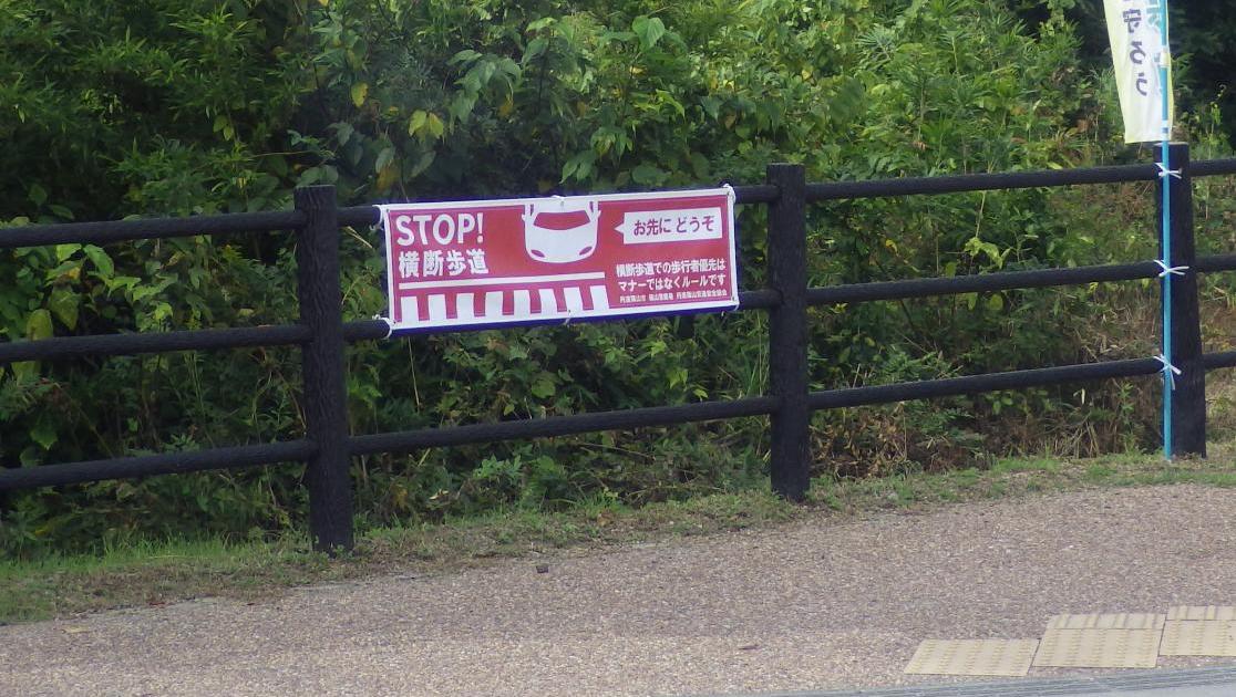 横断歩道の手前に、横断歩道で止まりますの横断幕が掲示してある