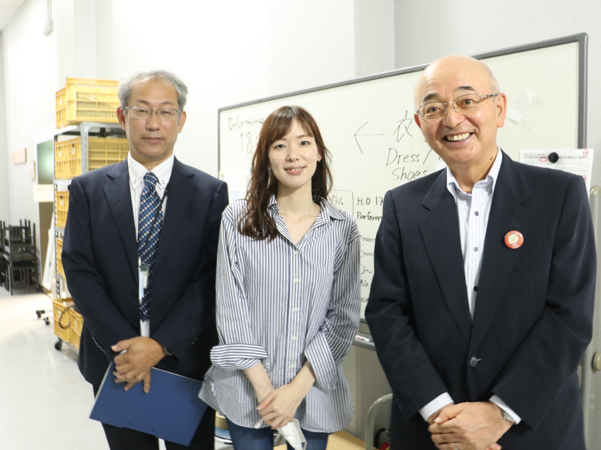 ステージ裏で、フルート演奏者の女性、市長、職員の記念撮影