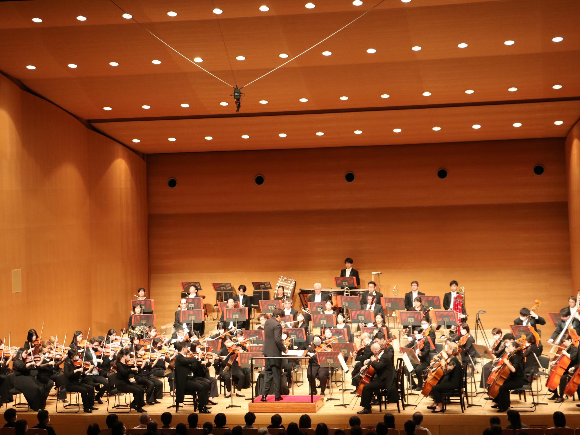 オーケストラの楽団が舞台で演奏している