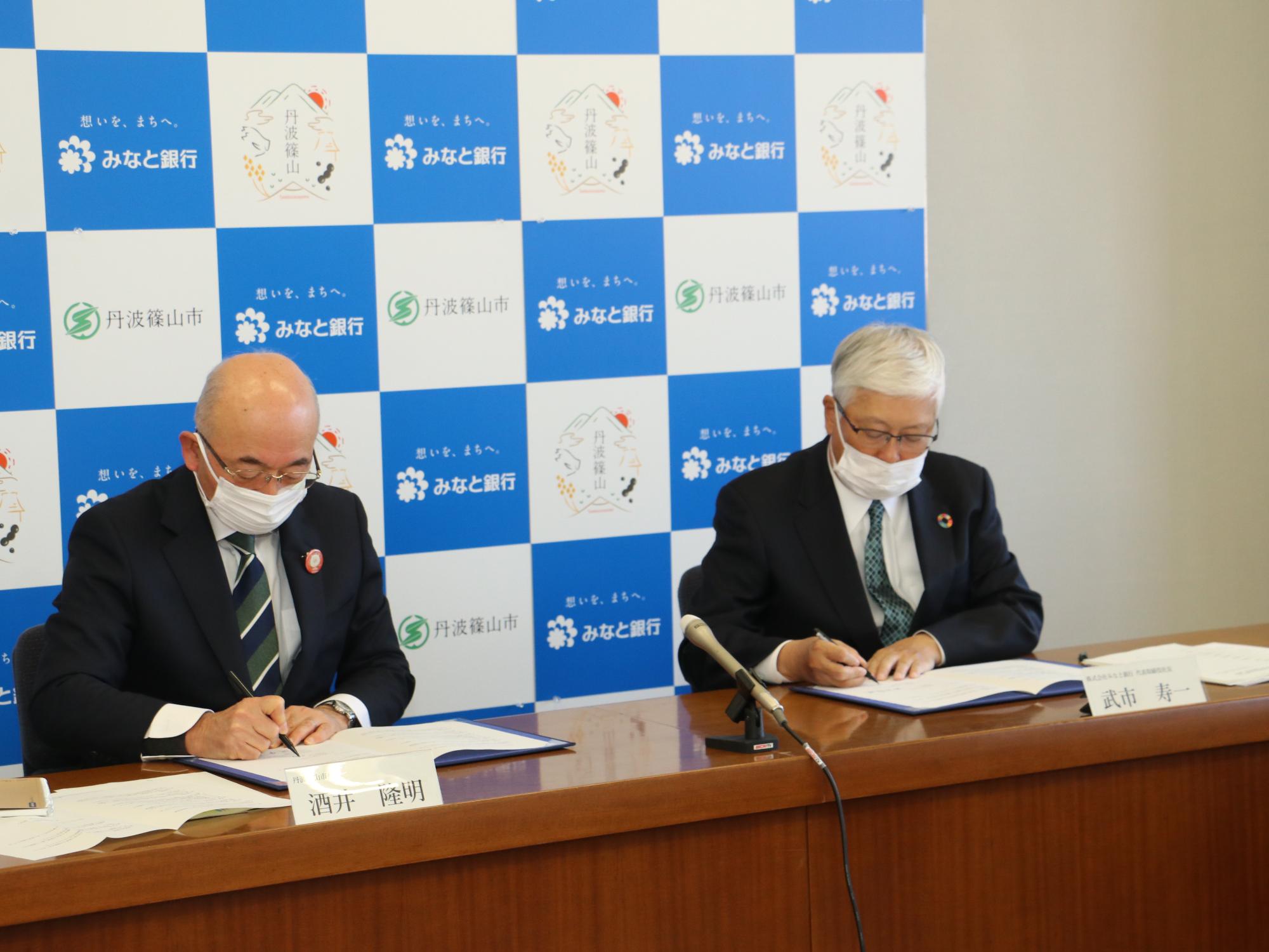 市長とみなと銀行代表が協定書に署名されている