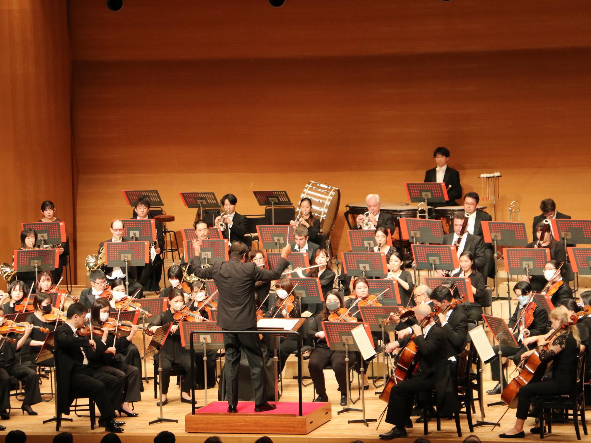 オーケストラの楽団が舞台で演奏している