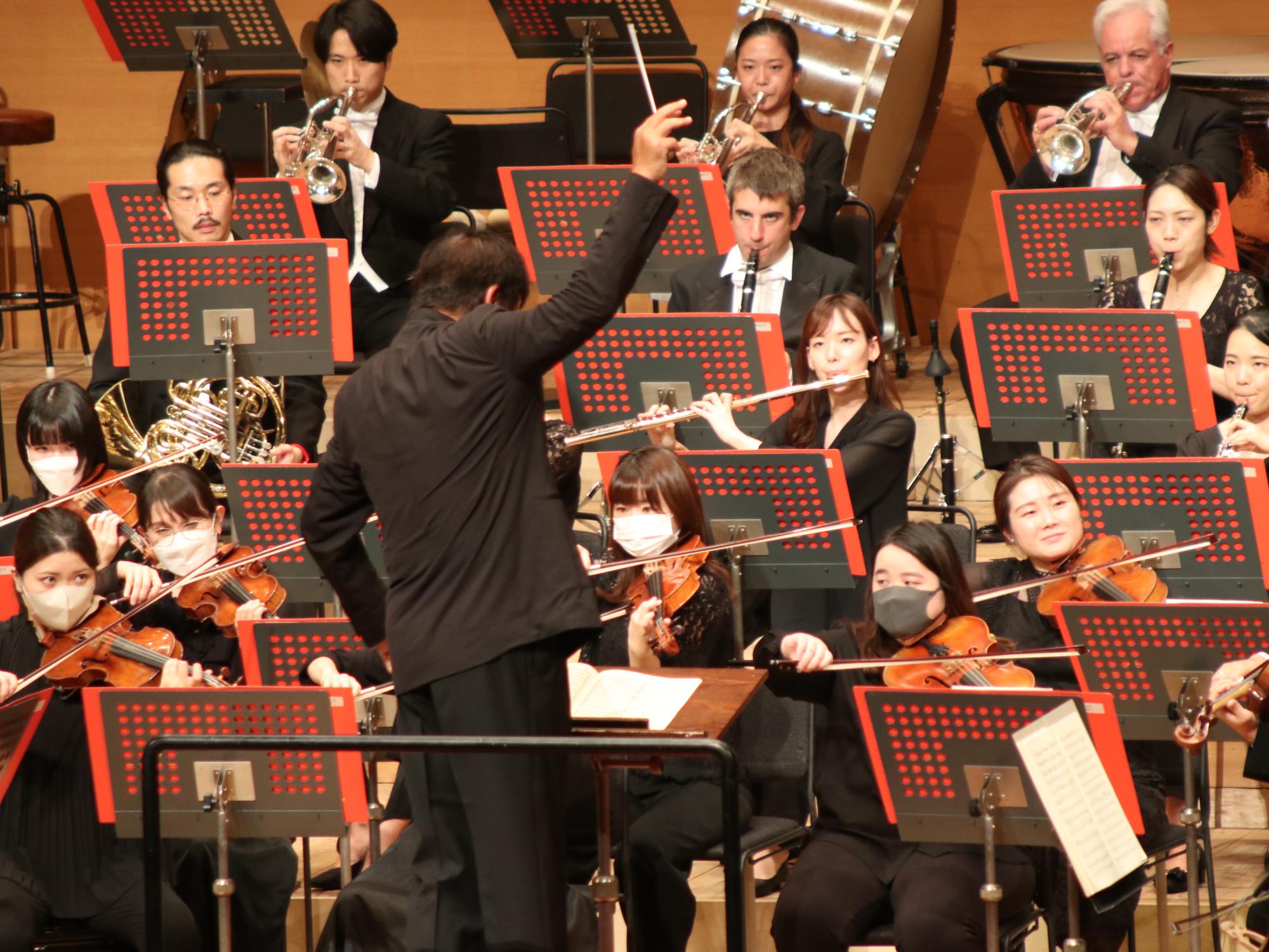 指揮者がタクトを振り上げている