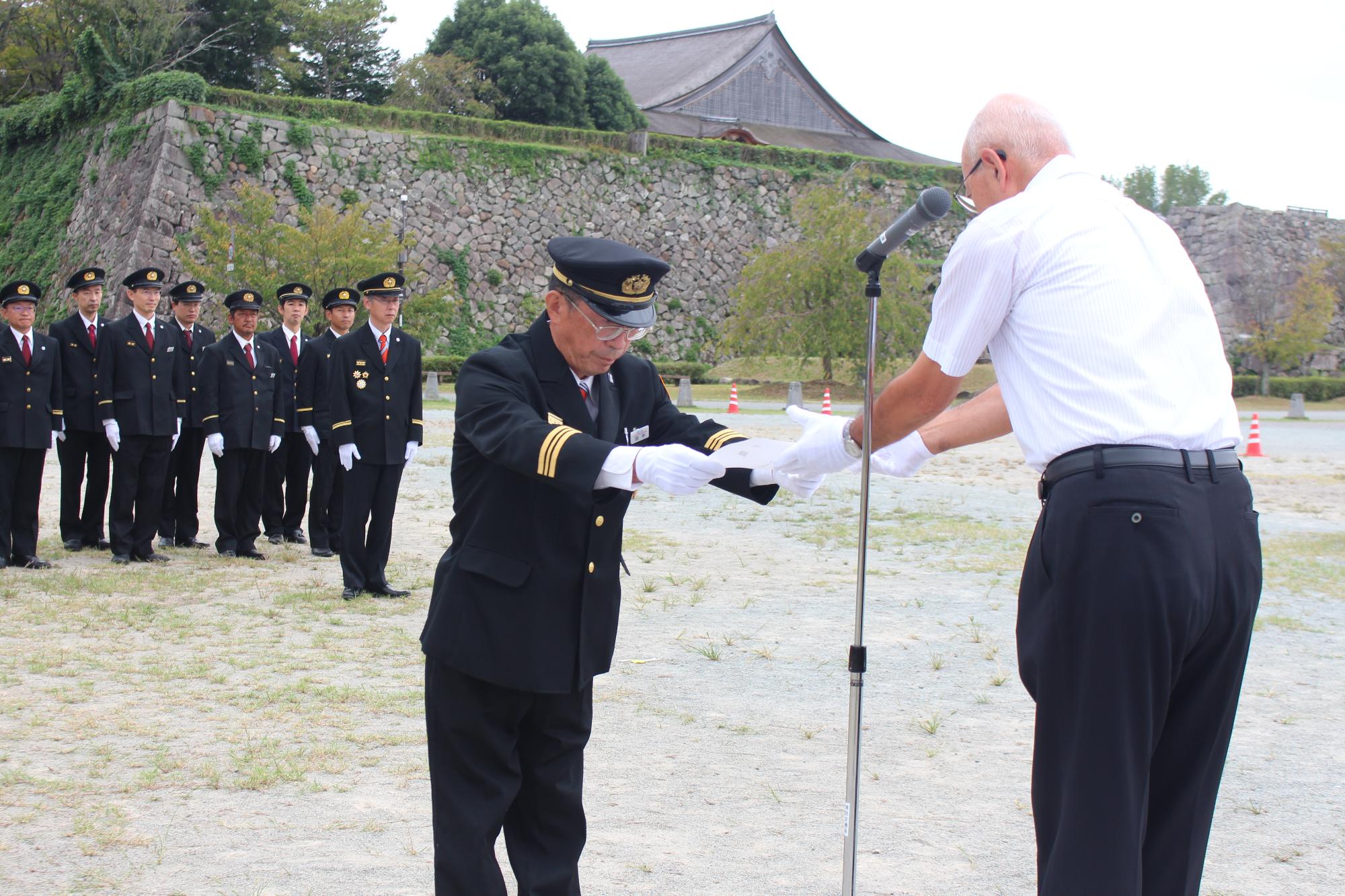 市長から田中消防団長へ目録