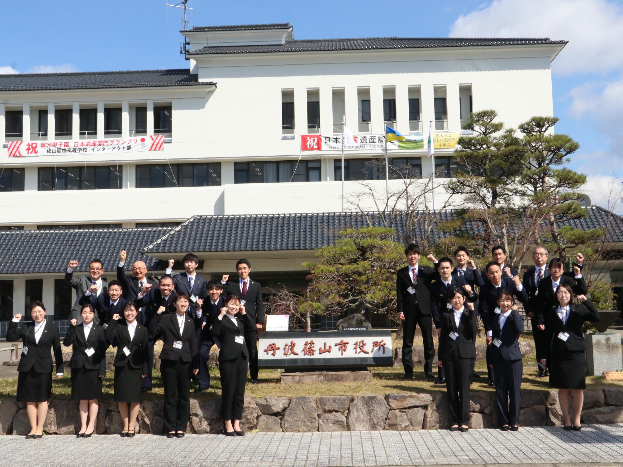 庁舎前で新規採用職員と市三役の記念撮影