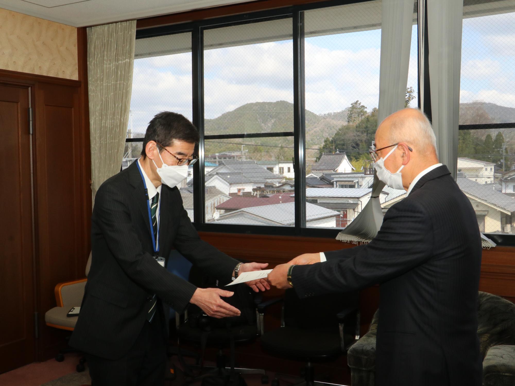 観光政策官が市長から辞令を受け取っている