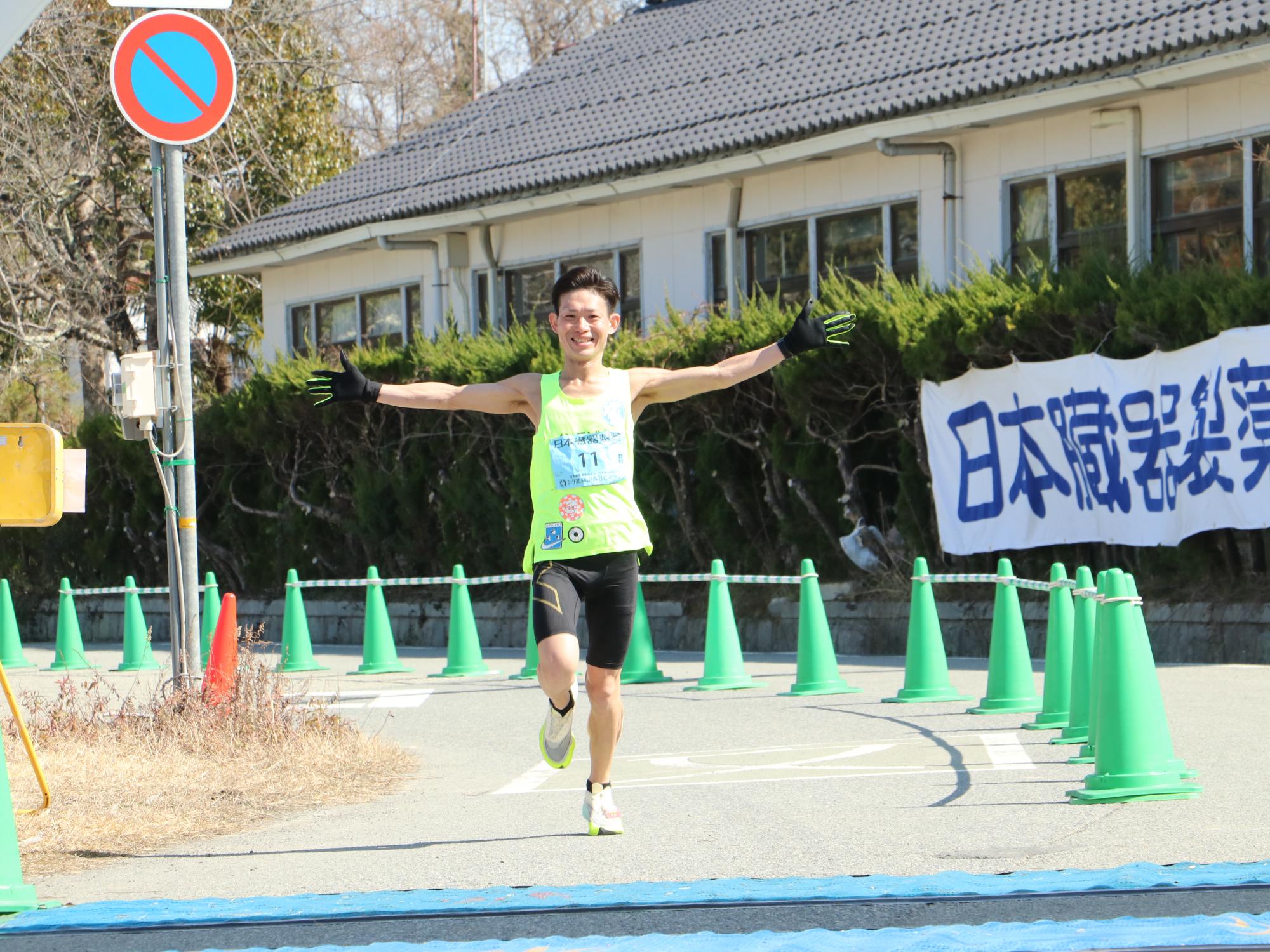 ランナーが両手を広げてゴールしている