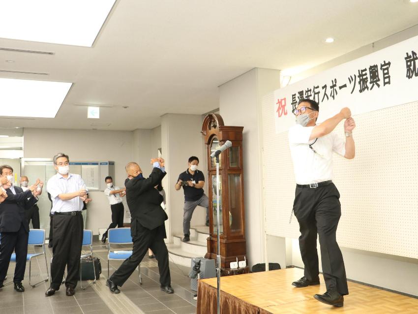 長澤先生の就任セレモニーで、教育長が壇上に上がり、皆とスイングする真似をしている