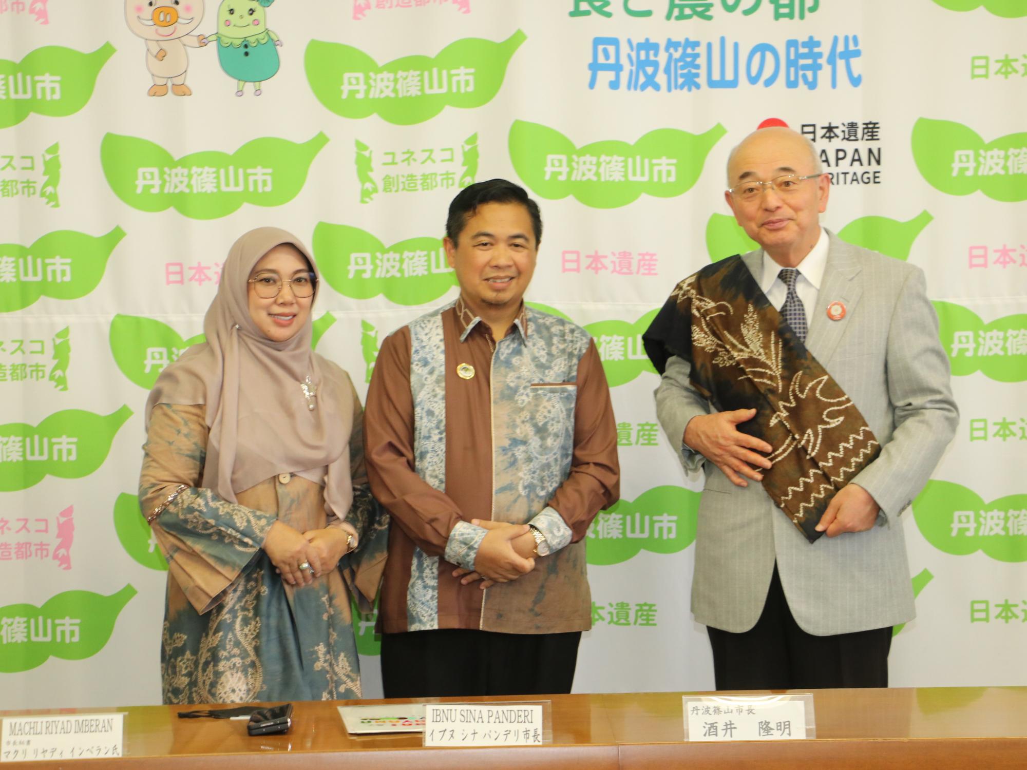 酒井市長がお土産の布を肩からかけ、バンジャルマシン市長、関係者の方の記念撮影されている