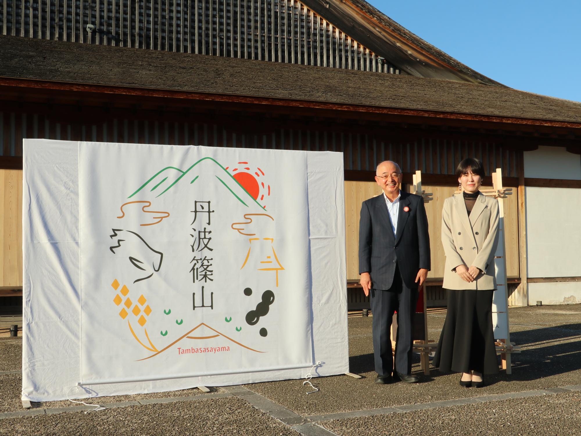 市長と岡田さん、ロゴの記念撮影