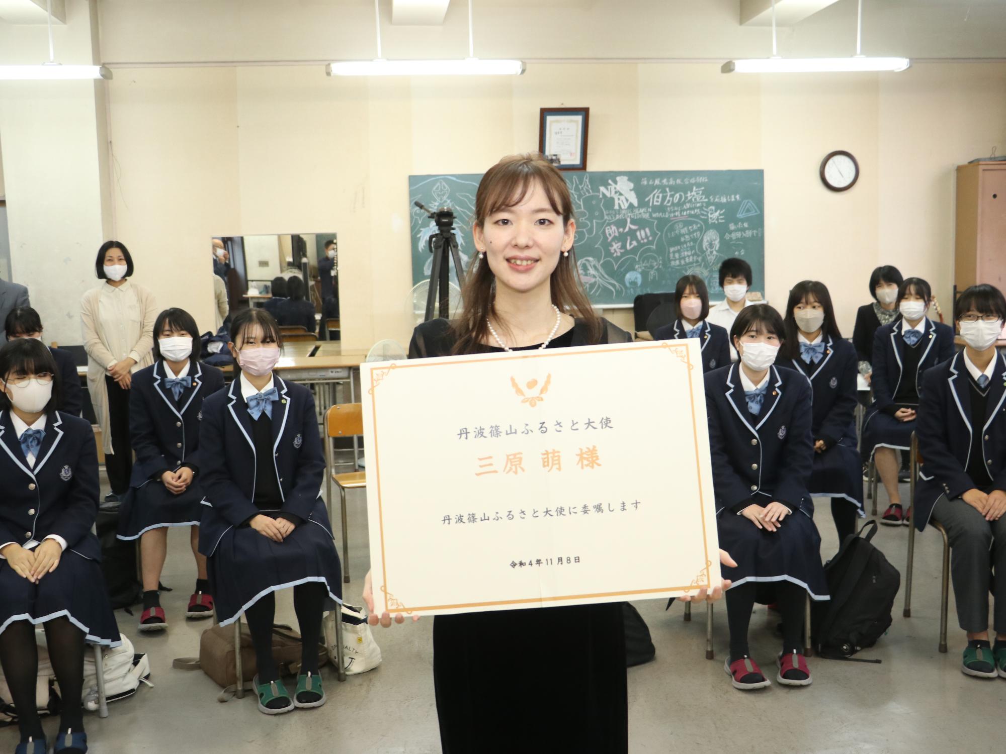 三原さんがふるさと大使の任命書を持っている