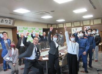 市長や教育長、幹部職員、若手職員がオーと手をあげている