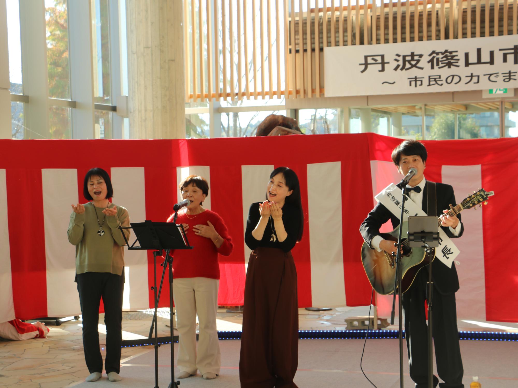 一日市長の雄介さんと歌声喫茶の皆さんが歌っている