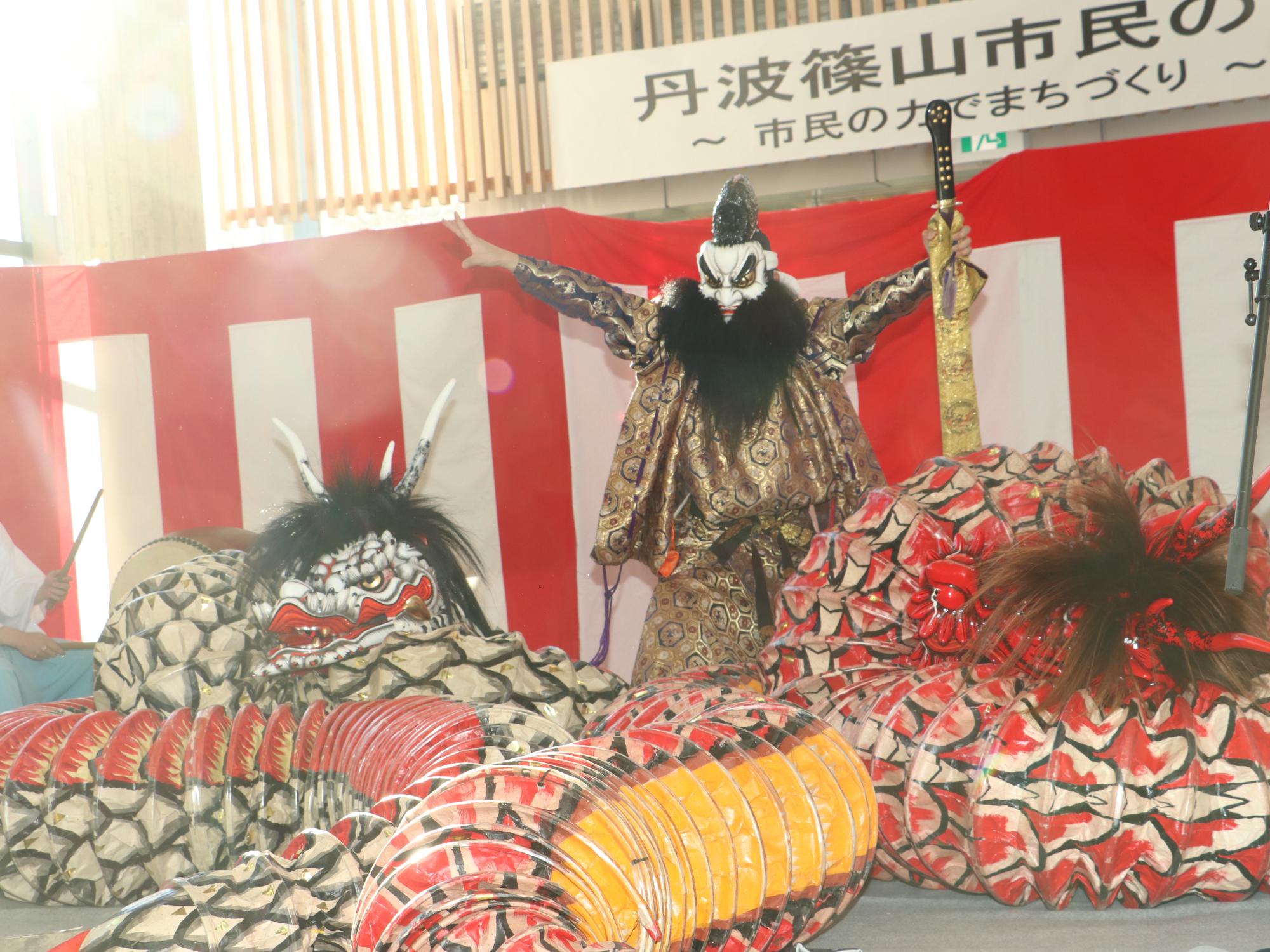 お面をかぶり、神楽を披露している