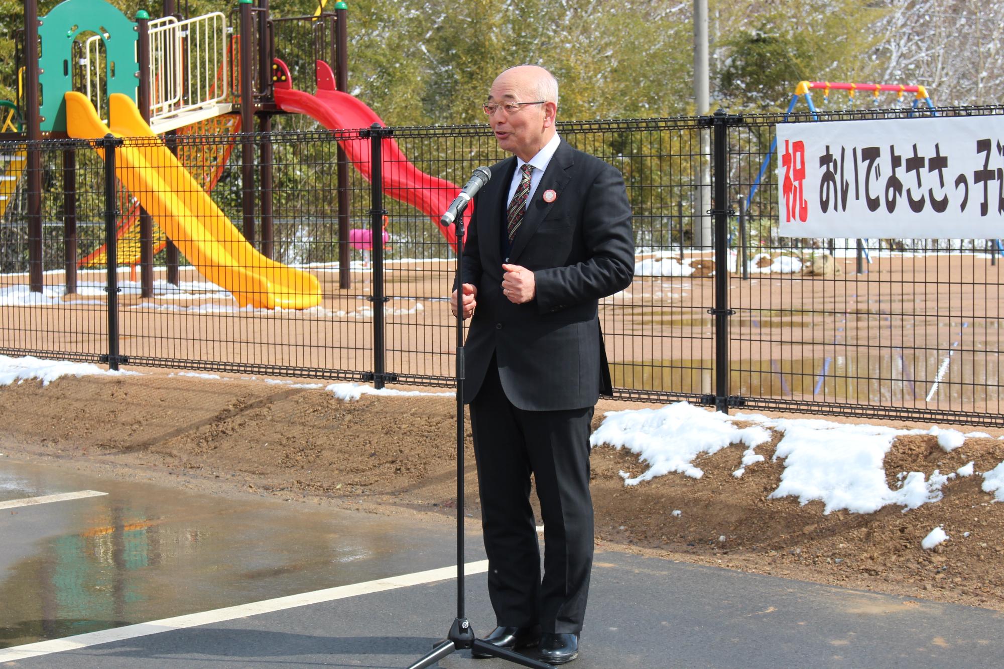市長が公園・遊具完成式で挨拶している
