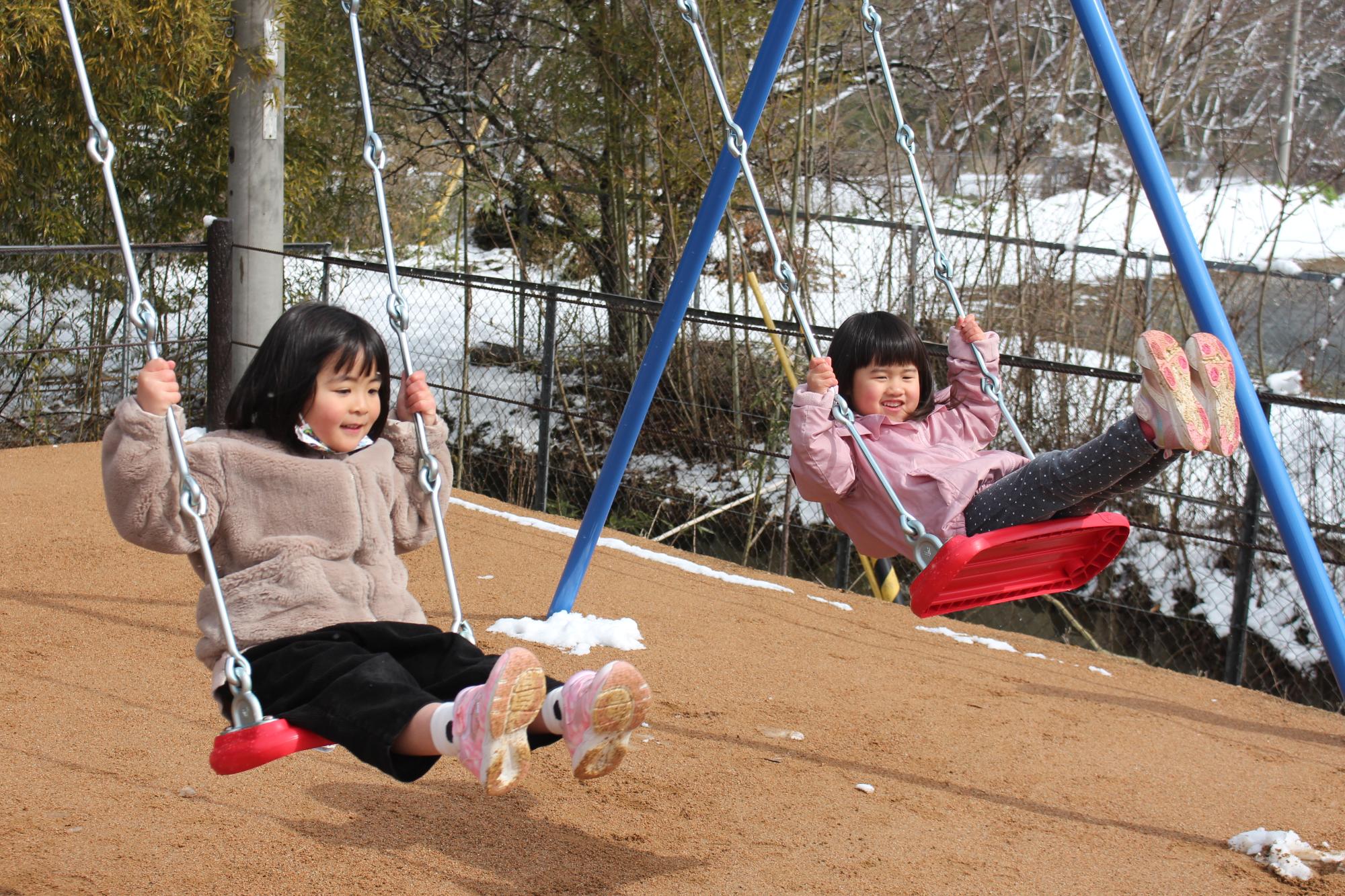 完成したブランコで子ども達が遊んでいる