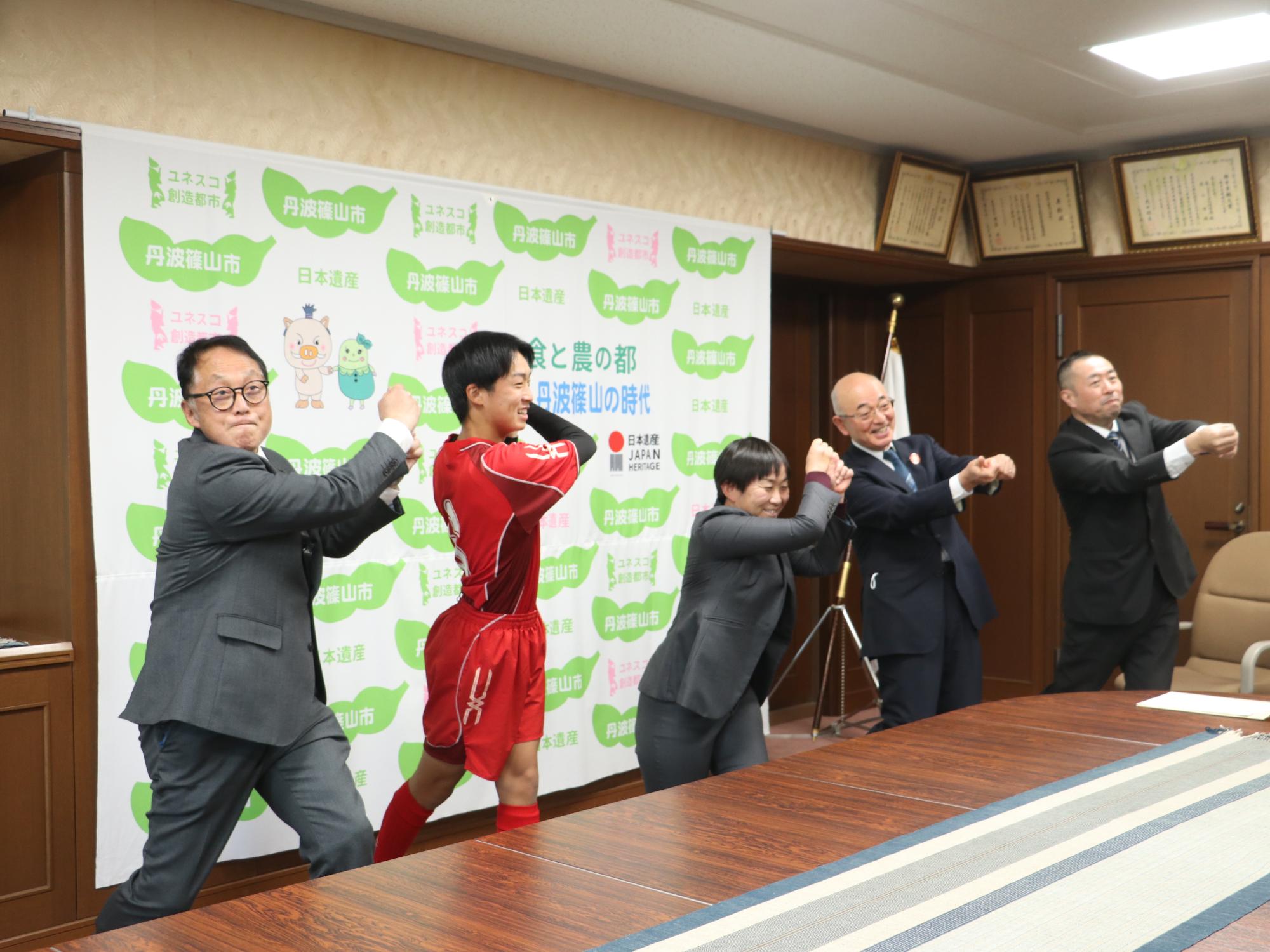 市長や教育長、永井君、学校の先生たちがスイングする真似をしている