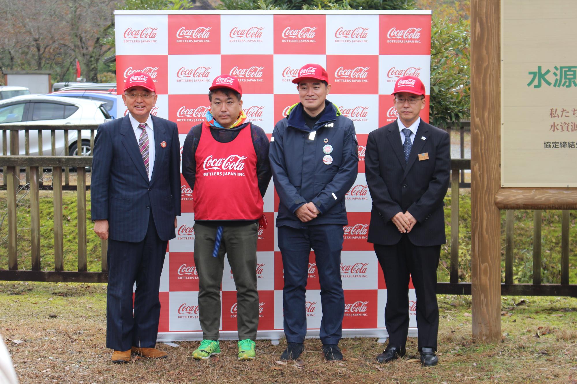 森開きで、コカ・コーラの赤い帽子をかぶって、市長、関係者の皆さんで記念撮影