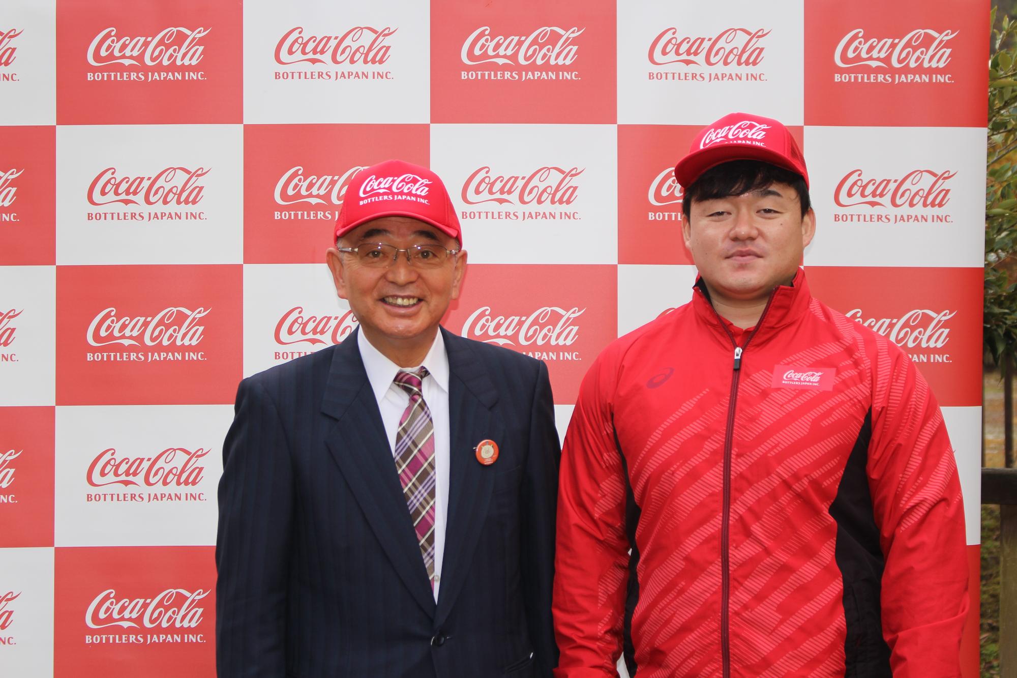 コカ・コーラの赤い帽子をかぶって、市長と政成さんの記念撮影