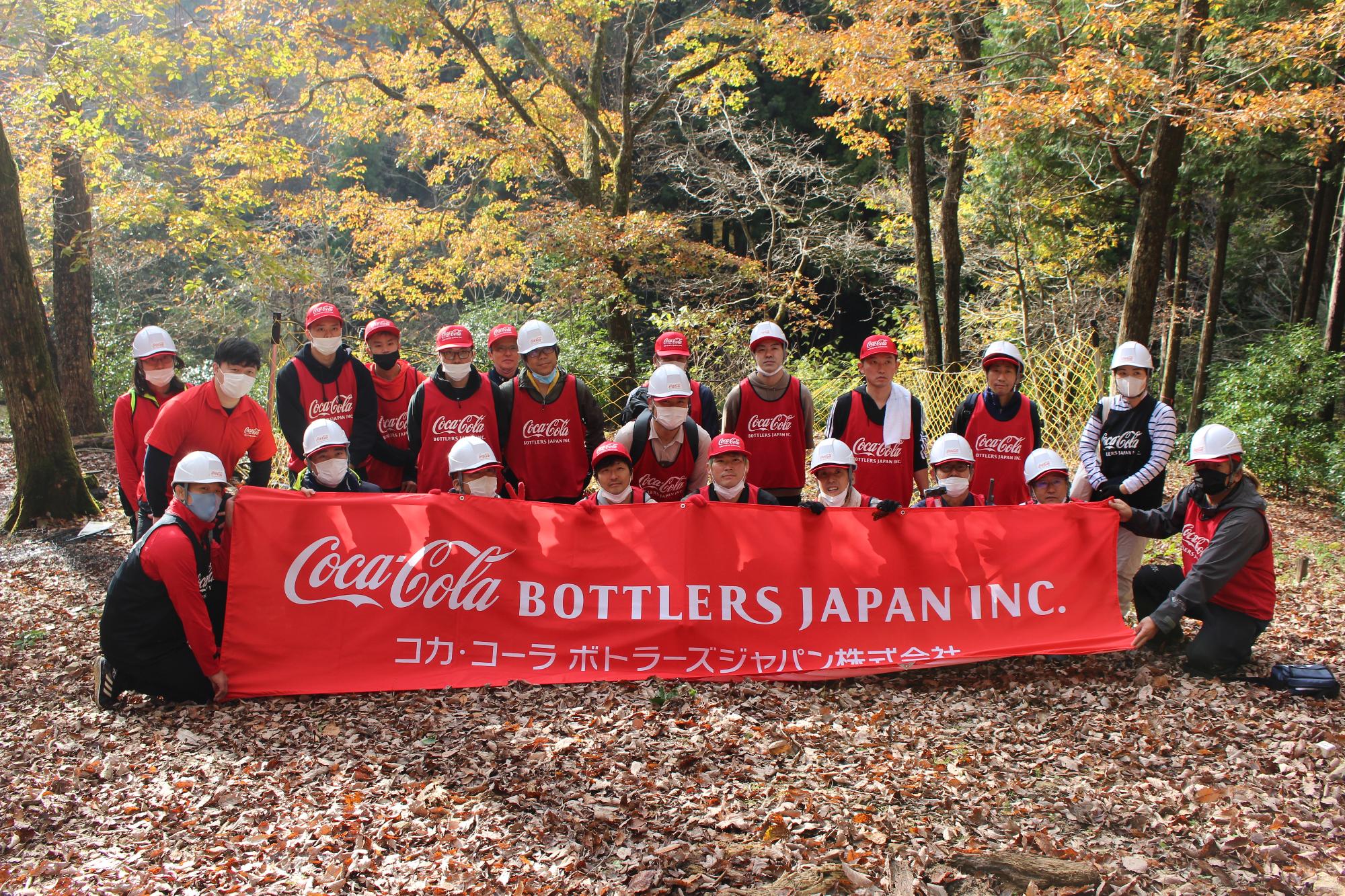 コカ・コーラの横断幕をもって、森開きの活動に参加された方で記念撮影