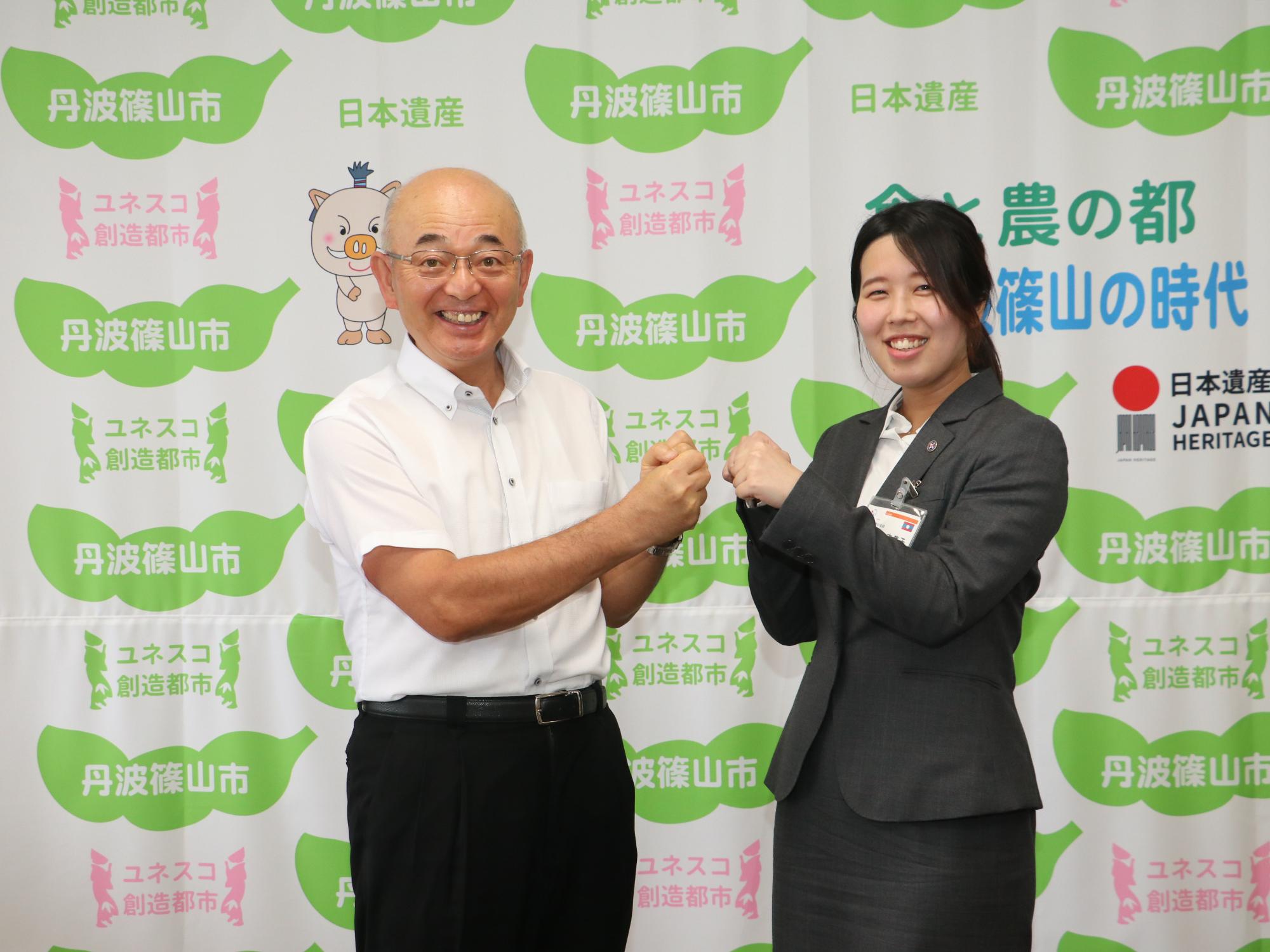 市長と女性が、記念にグータッチされようとしている