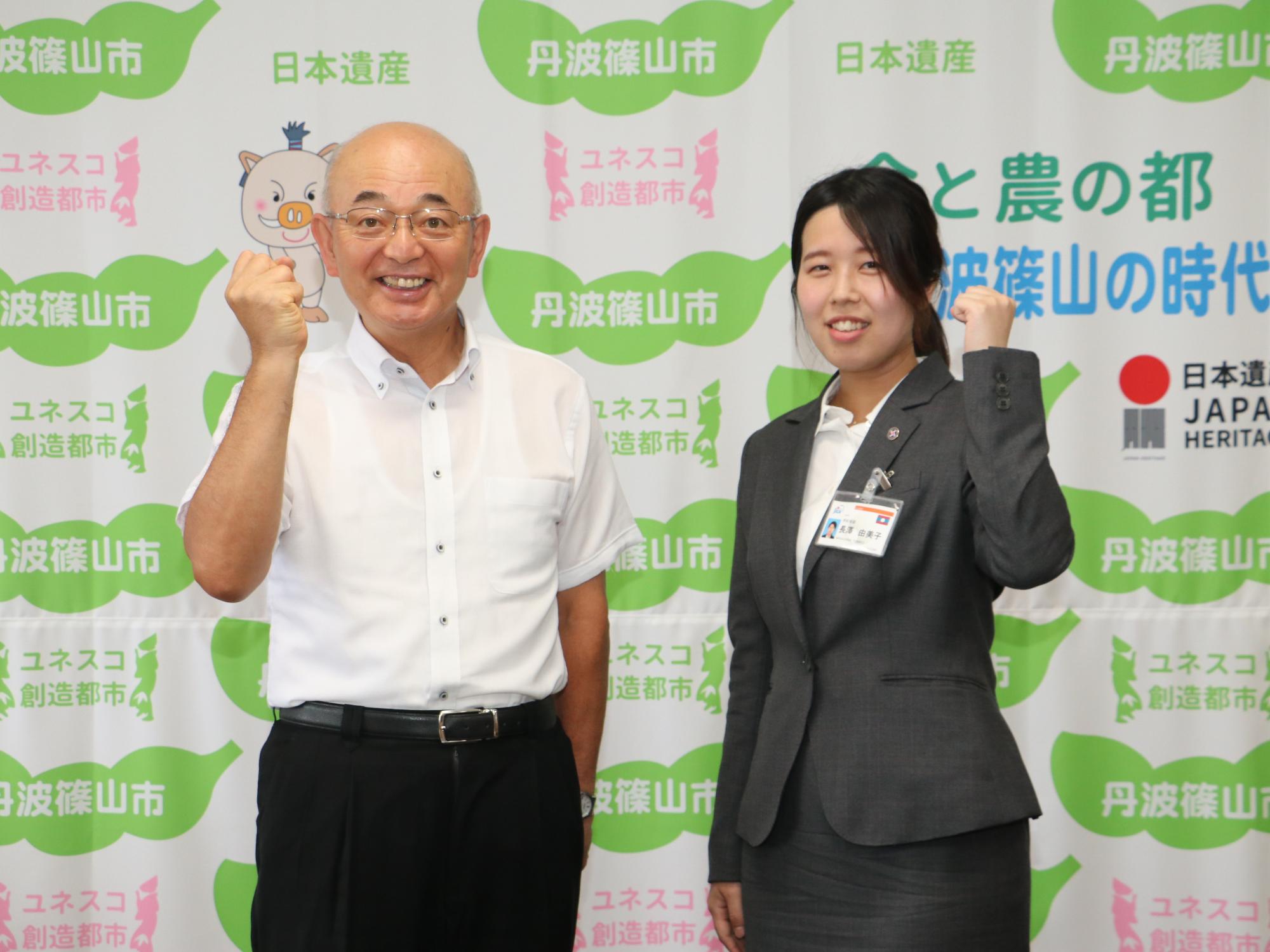 市長と女性がガッツポーズをしている