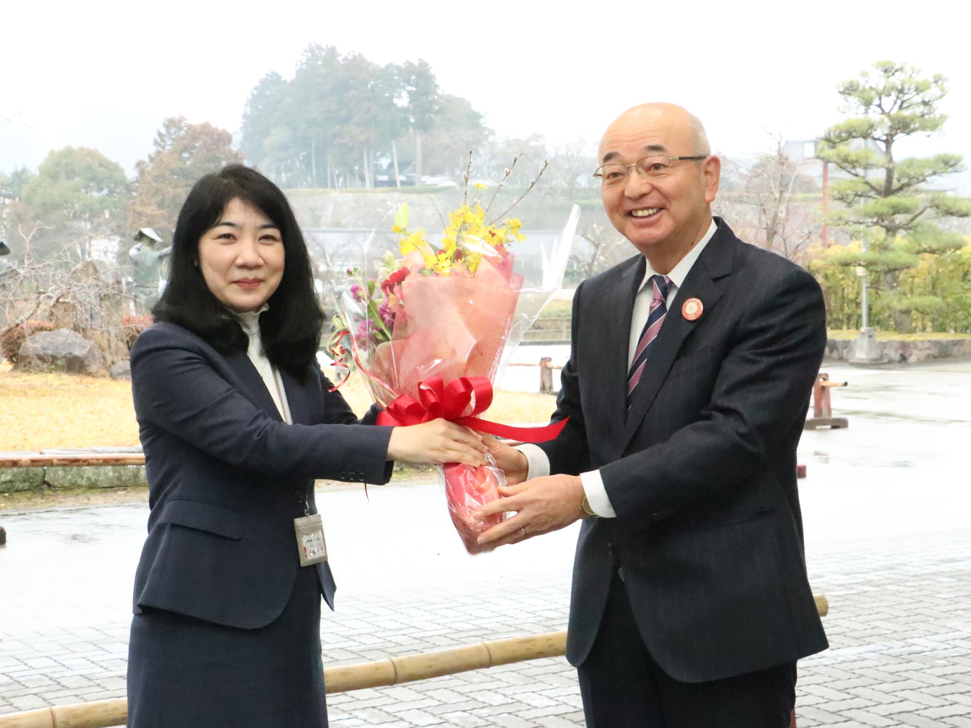 職員が市長に花束を渡している