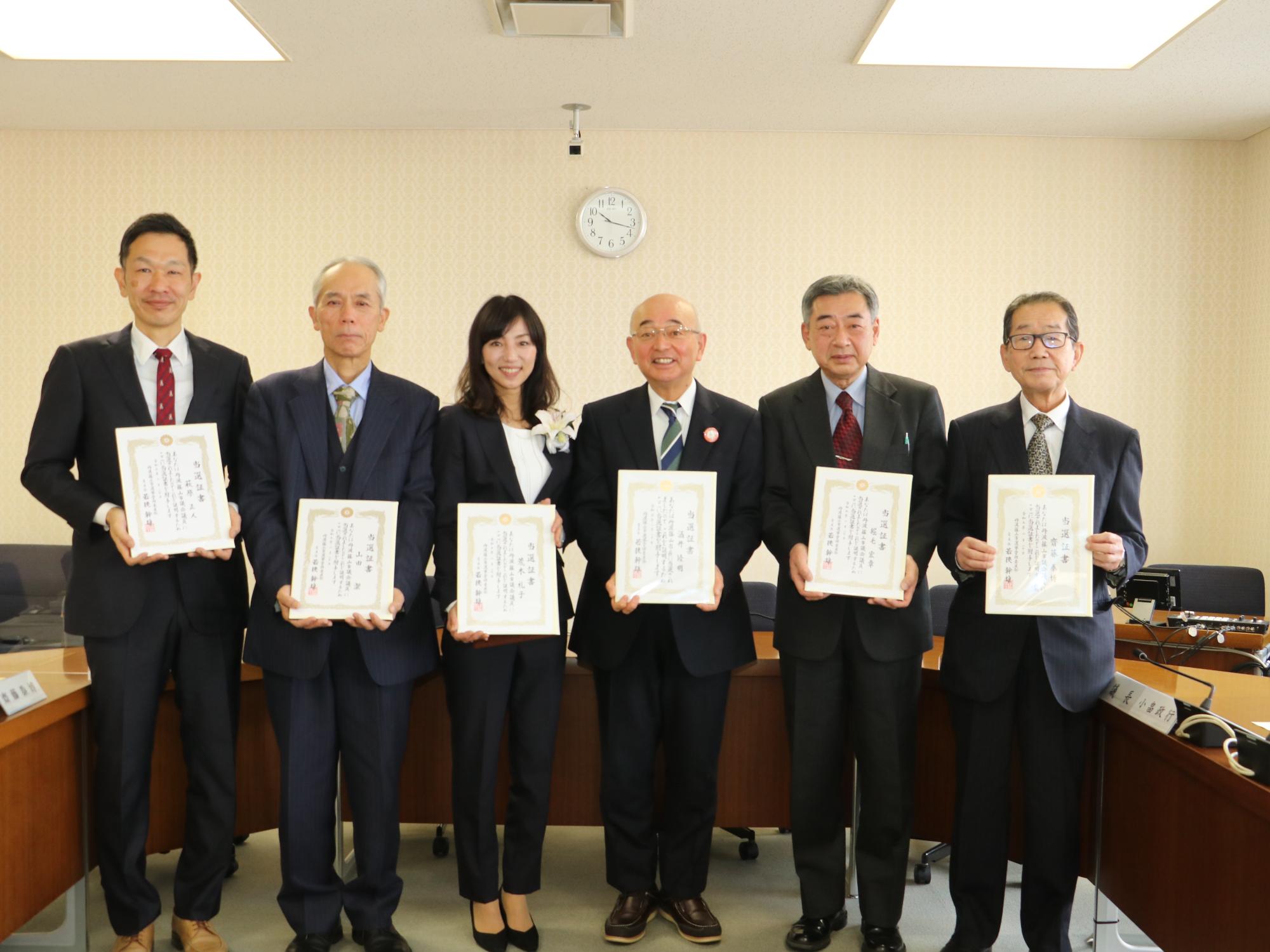 市長と新人議員5名が当選証書を持って記念撮影している