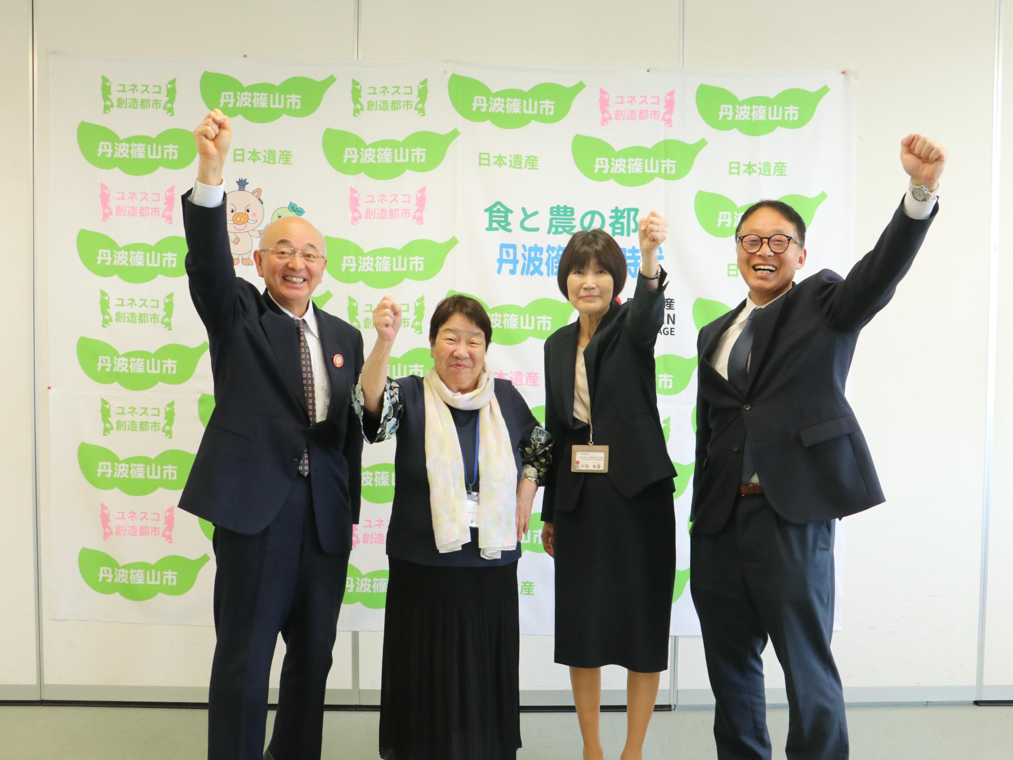 中川智子さんを囲んで拳をあげている写真