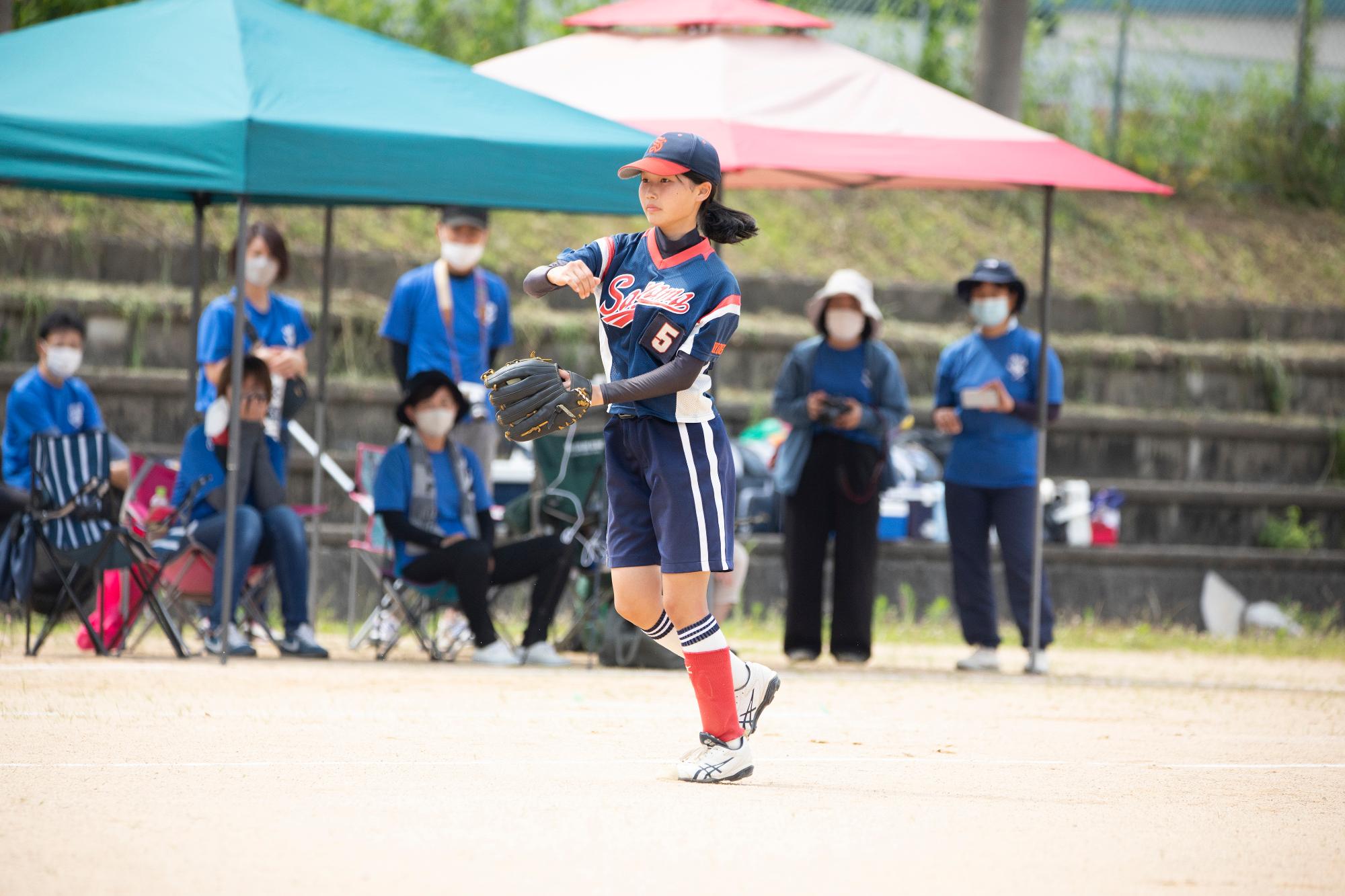 ユニフォームを着た女の子がボールを投げている