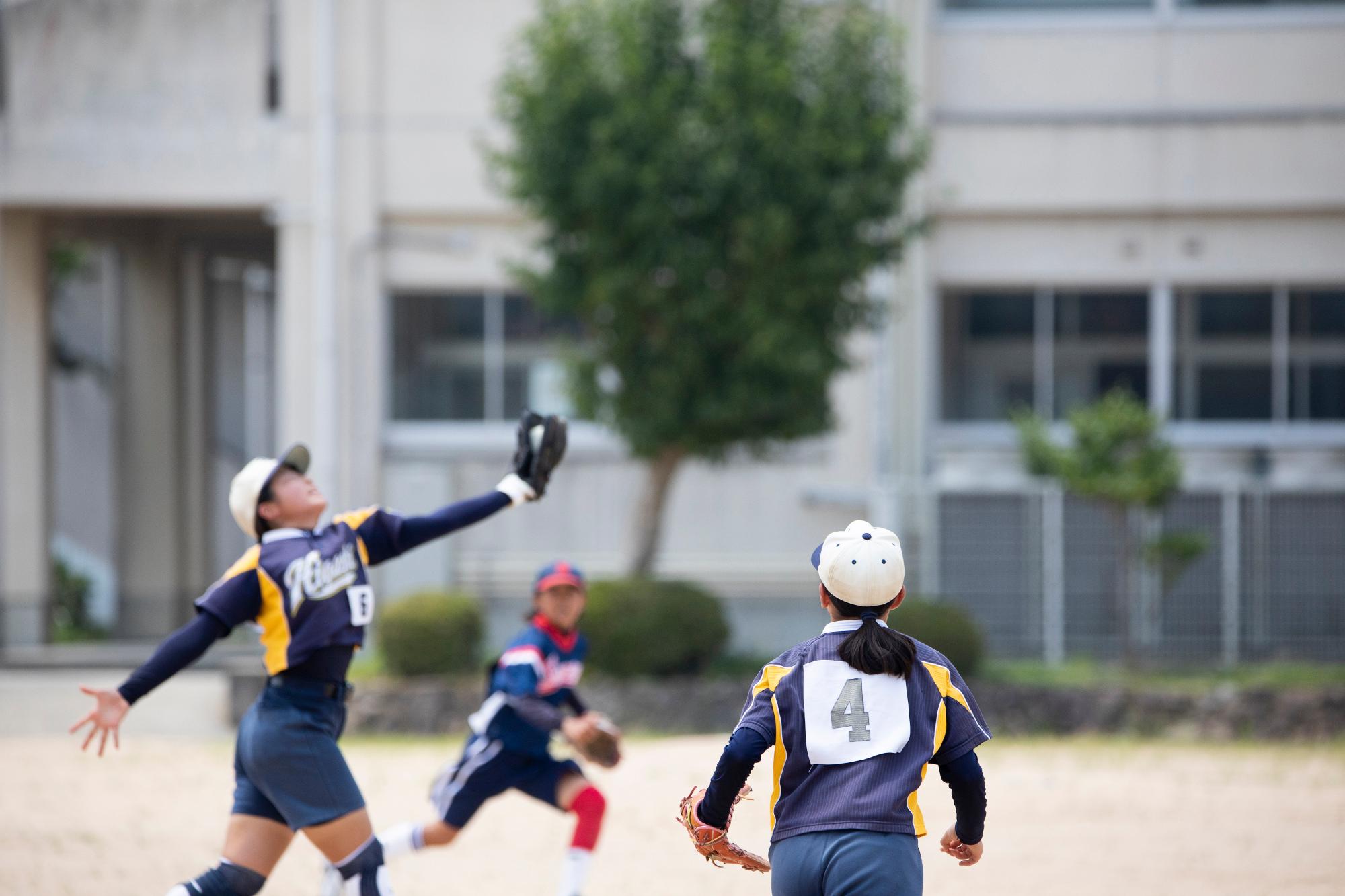 ソフトボールの試合でフライをキャッチしている