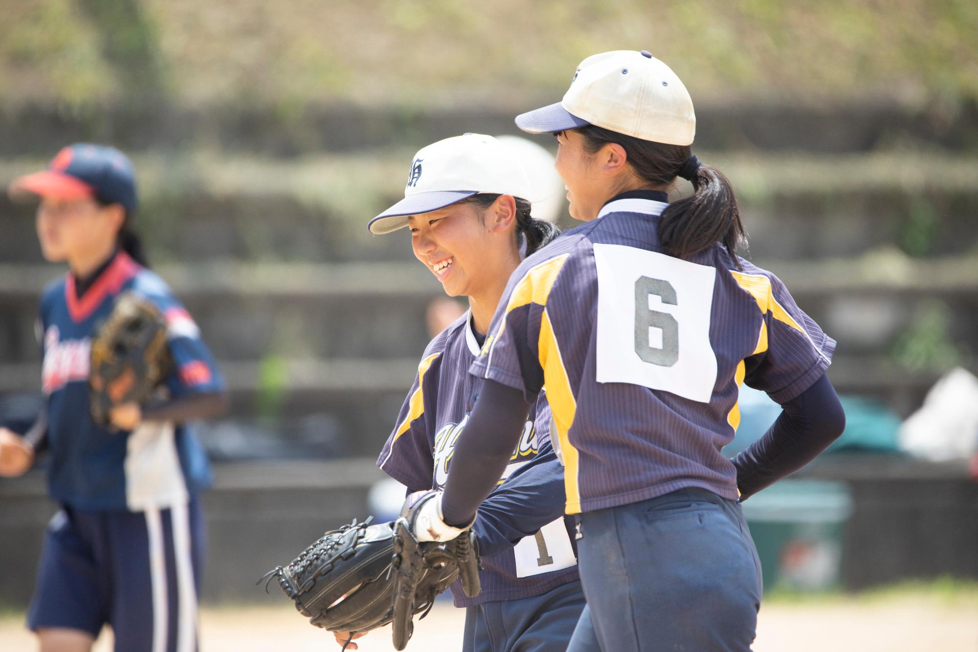 ソフトボールの試合で、選手が笑っている