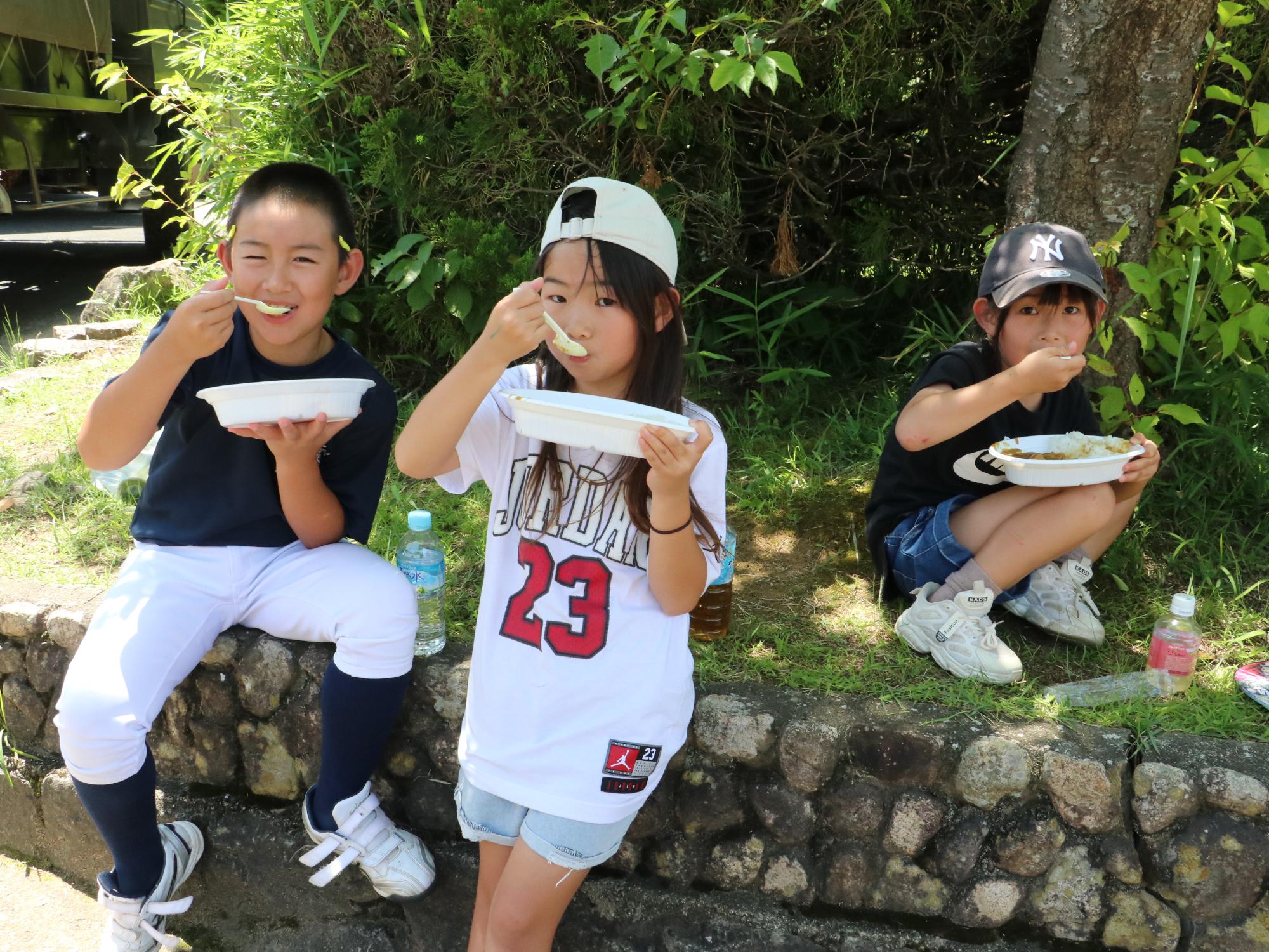 炊き出しのカレーを食べるこども