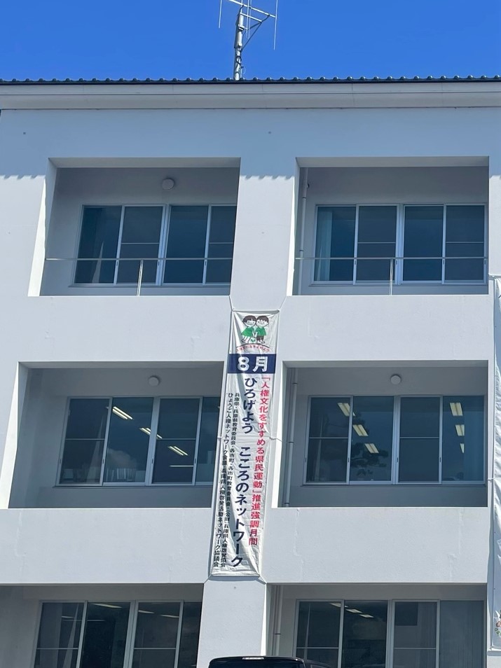 市役所第2庁舎の外壁に掲示されている啓発懸垂幕「8月ひろげようこころのネットワーク」の写真