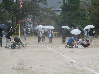 グランドの水取、土入れ、空模様を見ながら進行の相談など忙しく立ち回る教職員・保護者の皆さん
