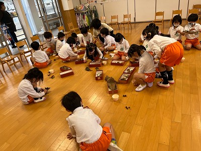自分が拾ってきたどんぐりで遊ぶ園児