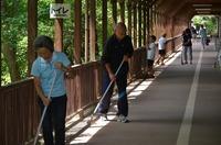 清掃道具を持った幅広い年齢層の人物が複数人で清掃活動を行っている写真