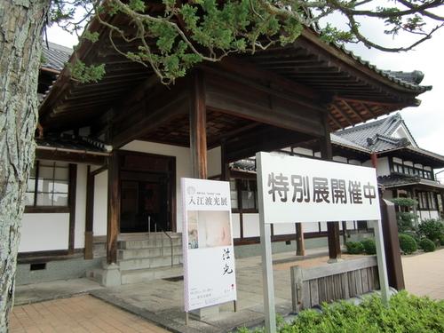 「特別展開催中」「入江波光展」の二つの看板が掲げられている美術館の入口付近外観の写真