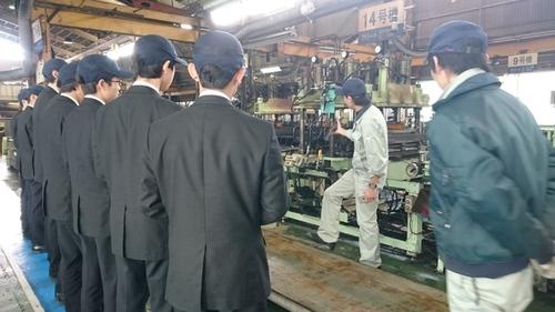 機械を説明する従業員の話を聞く篠山産業高校の生徒たちの写真
