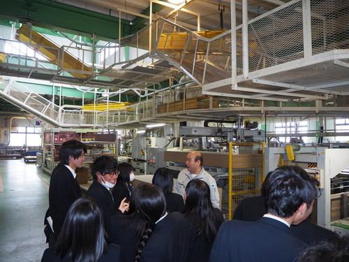 機械を説明する従業員の話を聞く篠山東雲高校の生徒たちの写真