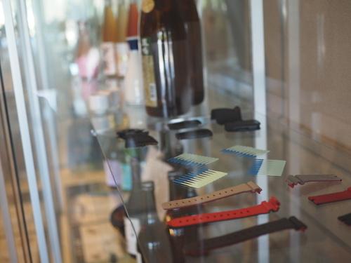 ケース内に入った篠山市企業紹介コーナーの酒類や腕時計のベルト等展示物を映している写真