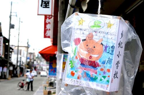 市内の小学生らが制作した豚が書かれた行灯が吊り下げられている様子の写真