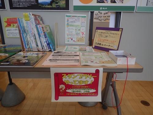 中央図書館内で展開しているスタンプリーの用紙とスタンプが置かれているコーナーの写真