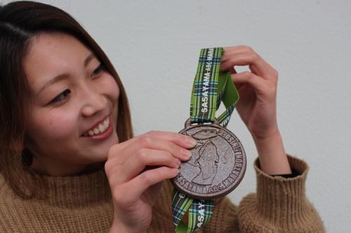 篠山ABCマラソン大会メダルを手に持った笑顔の女性の写真